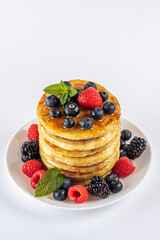 Delicious pancakes with fresh berries on white background. Food concept.