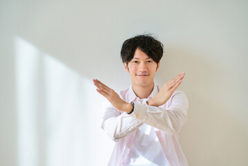 NGのサインをする若い男性