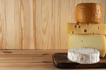 Assortment of different cheese types on wooden table. Cheese background.