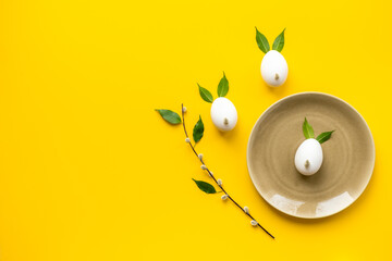 Easter background. Eggs in shape of bunnies made of spring leaves and willow bud, with willow sprigs