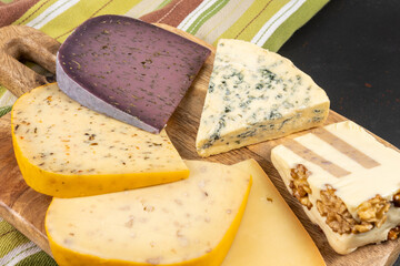 Various types of exclusive cheeses on dark background. Top view.