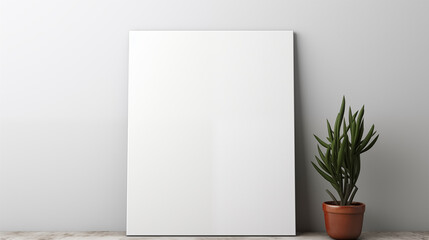 Blank canvas on a white wall with a potted plant on the side.
