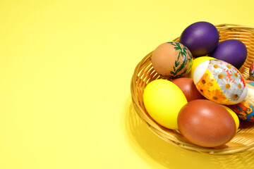basket with easter eggs isolated on yellow background copy space