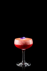 Fruity frozen strawberry margarita cocktail with violet flower isolated on a black background. Fresh alcoholic cocktail.