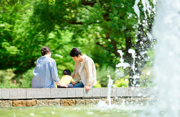 噴水のある公園で遊ぶ家族