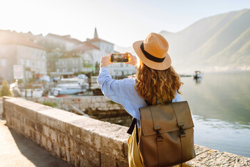 Woman taking picture of amazing landscape  on smartphone during vacation. Lifestyle, travel,...