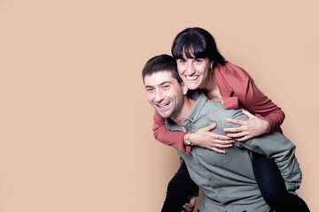 Fototapeta premium Happy caucasian couple in studio isolated beige background.