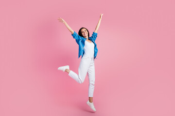 Full size photo of carefree peaceful gorgeous girl dressed blue shirt white trousers fly hold arms up isolated on pink color background