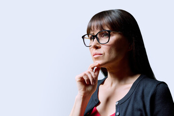 Close-up portrait of mature confident serious woman on white background