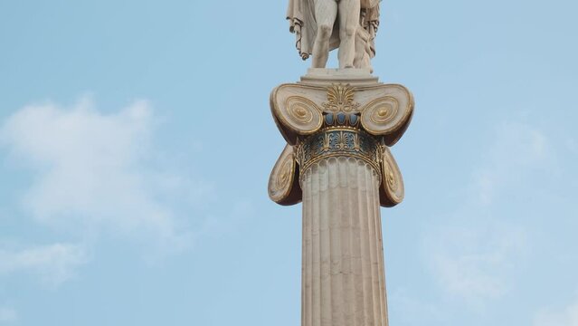 Statue of Apollo on marble column from the Academy of Athens, Greece against blue sky. Popular landmark and travel destination