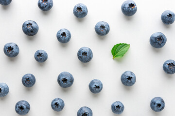 Fresh raw organic blueberries with green leaf on white background. Food concept.