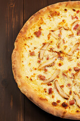 Pizza with pork gyros, tomato sauce, mixed cheese selection and onions on wooden background.