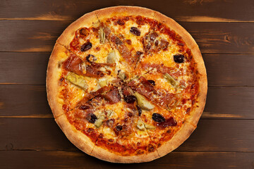 Top view of Pizza with tomato sauce, mixed cheese selection, ham, pepperoni, bacon, fresh mushrooms and olives.