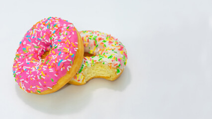 Two delicious donuts, white background, side view, copy space, 16:9