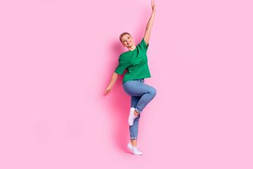Full length photo of optimistic gorgeous woman wear oversize t-shirt denim pants raising palm up isolated on pink color background
