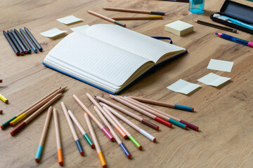 School accessories on wooden desk and notebook in the middle. Back to school concept. The beginning...