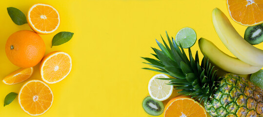Tropical fruits on the yellow background. Copy space. Close-up. Top view.