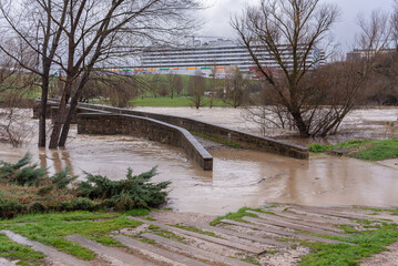 River flood over medieval bridge. Old Bridge of Burlada, Rio Arga