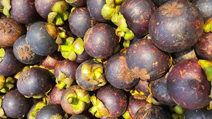 Close up pile of tasty fresh mangosteen sold at the market as a background.