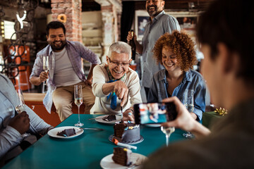 Senior woman celebrating birthday with colleagues in office