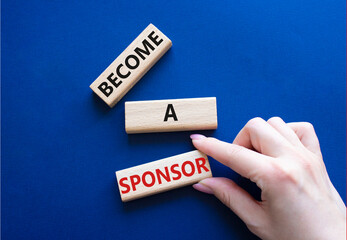 Become a sponsor symbol. Concept word Become a sponsor on wooden blocks. Businessman hand. Beautiful deep blue background. Business and Become a sponsor concept. Copy space