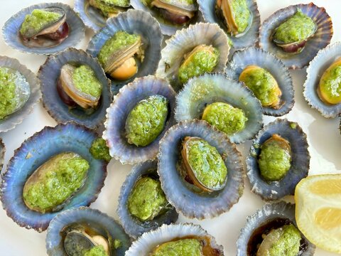 Canary Islands limpets with typical green &ldquo;mojo&rdquo; dip isolated close-up, seafood