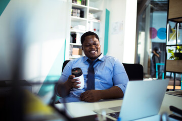 Young black businessman working on office laptop