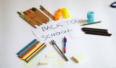 school accessories on a white background and white paper in the middle with 