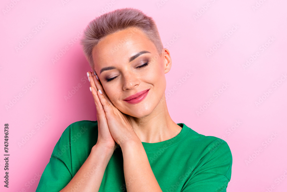 Wall mural Portrait of cute adorable person closed eyes folded hands palms under cheek empty space isolated on pink color background