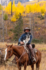 Cowboy giving dog a ride on horse