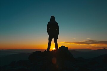 Silhouette of a person achieving the summit at sunset Symbolizing accomplishment - obrazy, fototapety, plakaty