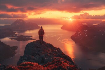 A person standing on top of a mountain at sunset. Ideal for outdoor and adventure concepts