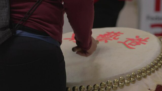 This video is shows a close up view of a drummer drumming a traditional Chinese drum instrument. 