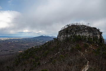 Pilot Mountain North Carolina with smaller peaks and clouds in background