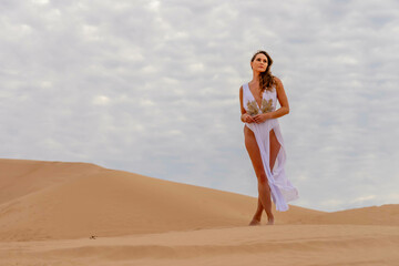 Fototapeta na wymiar Sculpted by Nature: Model's Grace Amidst Imperial Sand Dunes, California's Timeless Beauty Captured in Mesmerizing Photoshoot