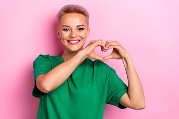 Photo of cheerful cute sweet woman demonstrate heart sign symbol isolated on pink color background