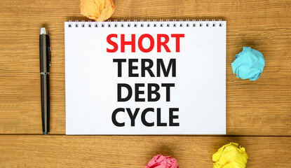 Short term debt cycle symbol. Concept words Short term debt cycle on beautiful white note. Beautiful wooden table background. Colored paper. Pen. Business Short term debt cycle concept. Copy space.