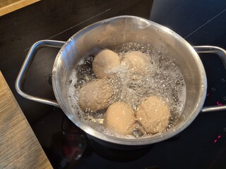 Jajka gotują się w metalowym garnku na śniadanie. 