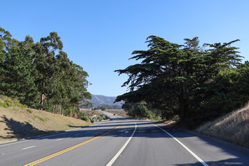 A stunning mountain scenery on a road trip, experiencing the beauty of nature under clear blue skies. Creates the perfect setting for an outdoor vacation filled with excitement. Fast road mountains. 