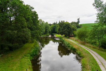 Une vue charmante s'offre sur le canal, où les arbres arborent leur feuillage vert vif, avec une...