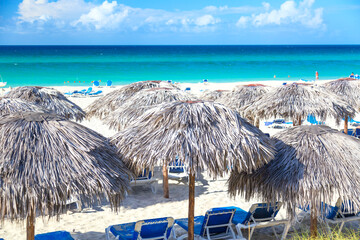 Straw umbrellas and sun loungers on the beach in Varadero, Cuba. Vacation background