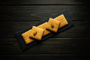 Shortbread cookies on a black serving board with almond nuts prepared for dessert in a tavern. Sweet snack concept with nuts on vintage table