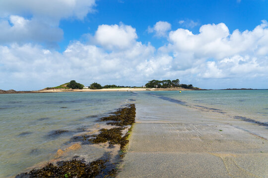 Vue sur l'&icirc;le Callot, accessible &agrave; mar&eacute;e basse, lors d'une mar&eacute;e descendante en Bretagne, r&eacute;v&eacute;lant un paysage maritime spectaculaire.