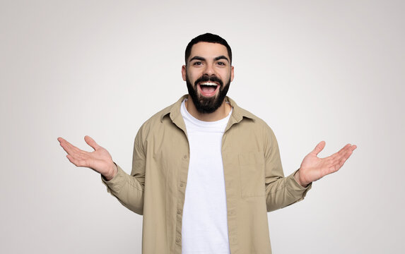 An exuberant man with a beard joyfully spreads his hands wide open