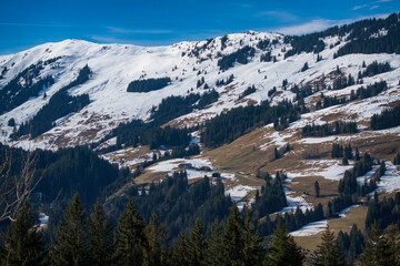 hiking holiday in the austrian mountains with a beautiful view of the snow capped alps at a sunny spring day