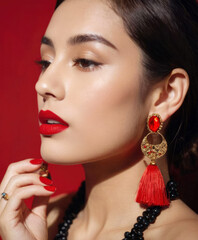 Model with statement earrings and red lipstick, backlit photography, close-up shots, bold tropical baroque style