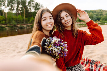 Naklejka premium Happy women taking selfie on the beach. Spring weather. Holidays, technology, blogging concept.