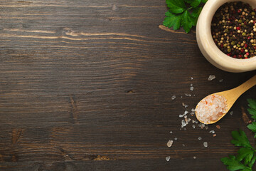 Cooking background, home cooking concept. Spoon, herbs and spices on wooden background, top view, copy space.