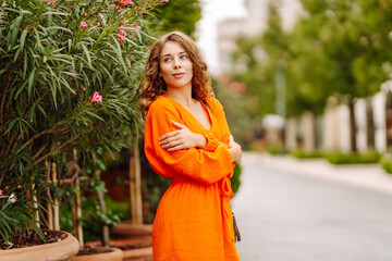 Happy woman in summer dress walking in the city street. Fashion, beauty, lifestyle, travel concept.