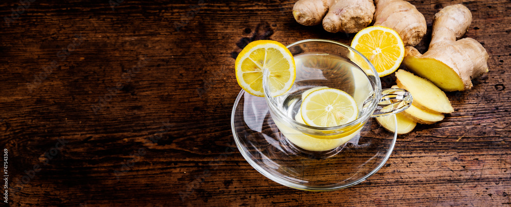 Wall mural a glass cup of ginger tea on a wooden table